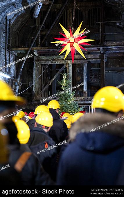16 December 2023, Lower Saxony, Goslar: Visitors wearing hard hats at a Christmas market in a gallery of the Rammelsberg Mining Museum