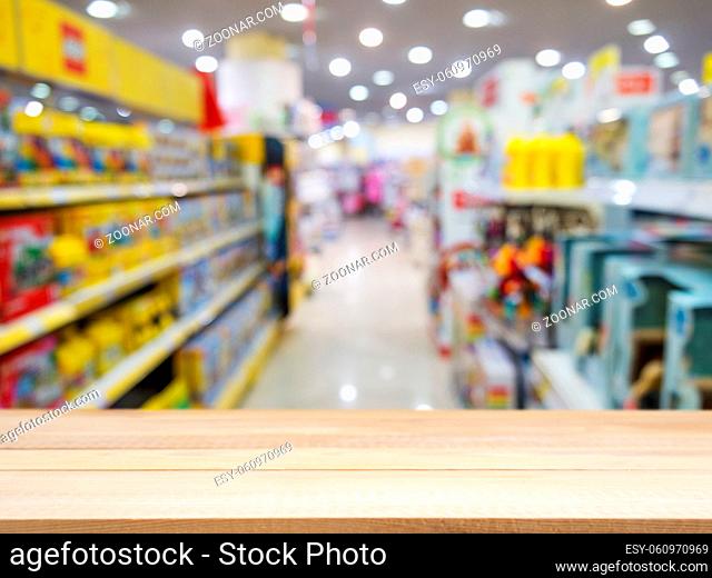 Wooden board empty table in front of blurred background. Perspective light wood over blur in kids toys store - can be used for display or montage your products