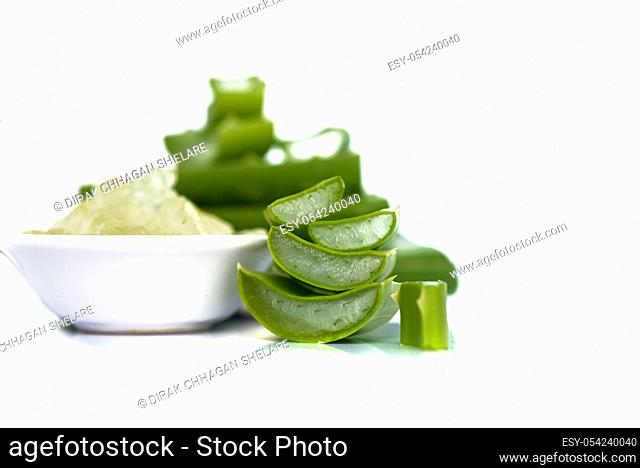 Slices of Aloe Vera leave and Aloe Vera gel in a bowl on a white background. Aloe Vera is a very useful herbal medicine for skin care and hair care