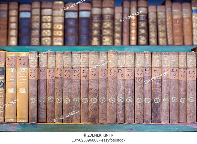 historic old books in ancient library, wooden bookshelf