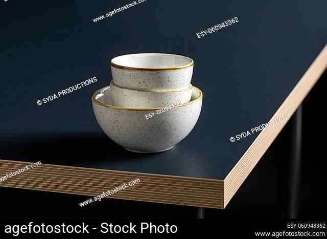 close up of white ceramic bowls on black table