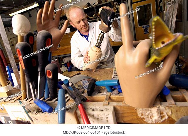 A technician building a prosthetic leg at a prosthesis workshop