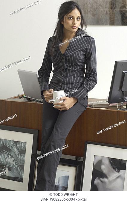 Middle Eastern businesswoman next to framed photography