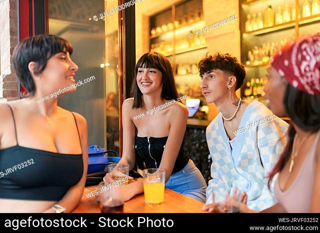 Smiling friends talking in restaurant