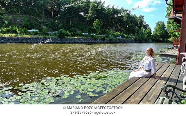 Woman sitting in the Porvoonjoki river in Porvoo, Finland