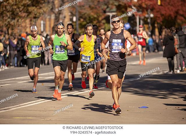 Orange sneakers on runners as they pass through Harlem in New York near the 22 mile mark near Mount Morris Park on Sunday, November 4