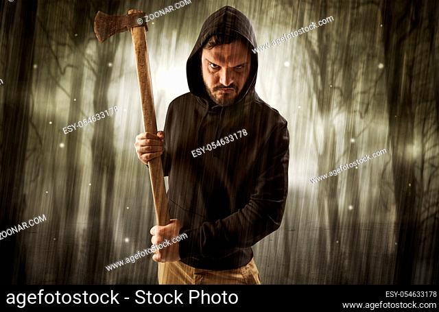 Masked armed hitman in dark thick forest with foggy mysterious concept