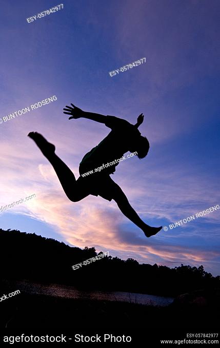 Silhouette happy jumping against beautiful in sunset. Freedom, enjoyment concept