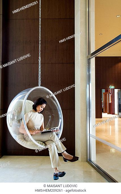 United Arab Emirates, Dubai, Dubai Festival City, Intercontinental Hotel, Lounge, woman sitting in a Bubble Chair by Eero Aarnio