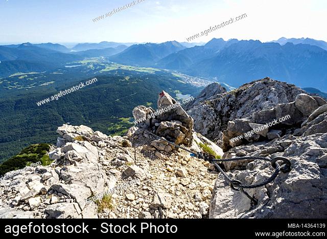 Wire rope belay at the Wetterstein summit, above Mittenwald and the Werdenfelser Land. iIn the valley, the Lautersee is clearly visible