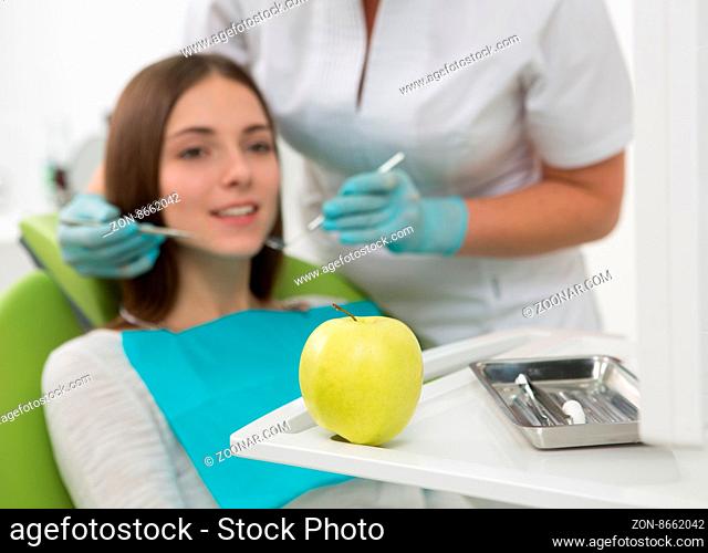 Close-up picture of an apple represented with dentist#39;s instruments and equipment at the dentist#39;s office