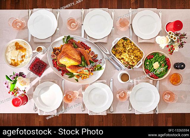 Set table with roast turkey and side dishes