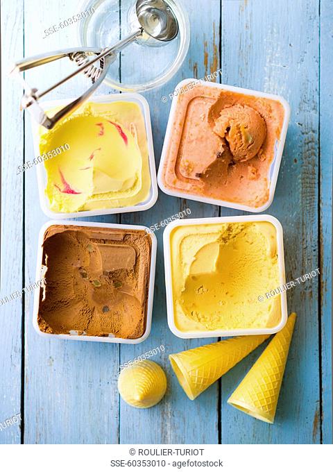 Assortment of punnets of ice cream, ice cream cones and ice cream scoop