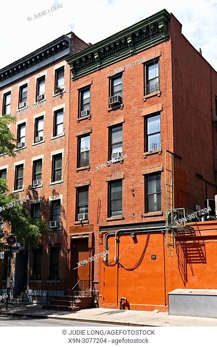 Looking at an Old Tenement Apartment Building, with Altered Garage, in the Clinton/Hell's Kitchen Neighborhood of Manhattan, New York City, USA