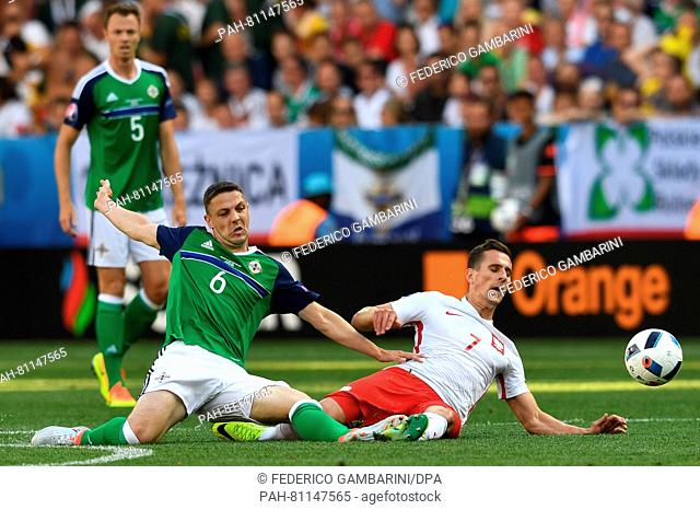 Arkadiusz Milik (R) of Poland and Chris Baird of Northern Ireland challenge for the ball during the UEFA Euro 2016 Group C soccer match between Poland and...