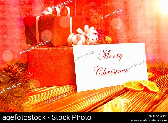 two christmas presents on a wooden table with a greeting card
