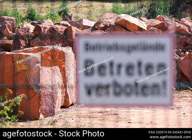 PRODUCTION - 11 September 2023, Saxony, Rochlitz: A sign ""Company premises, no trespassing!"" warns at the entrance to the Rochlitz Porphyry Manufactory quarry