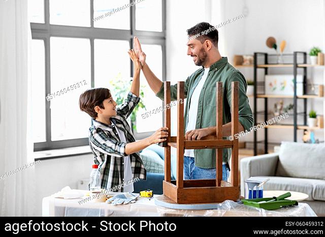 father and son making high five and restore table