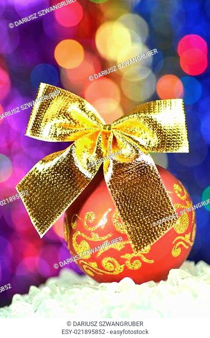 christmas decoration, red Christmas ball with golden bow in bokeh background