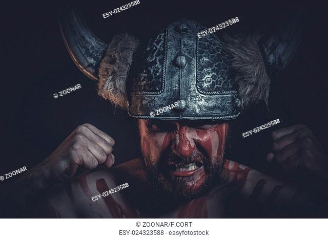 Aggression, Viking warrior with a horned helmet and war paint on his face