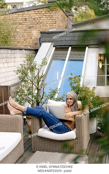 Woman relaxing on terrace using laptop