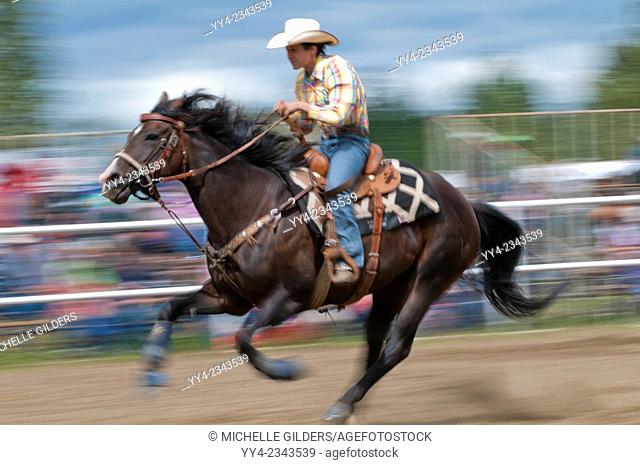 Motion blur of a cowgirl riding fast during barrel racing, Caroline Stampede, rodeo, Caroline, Alberta, Canada