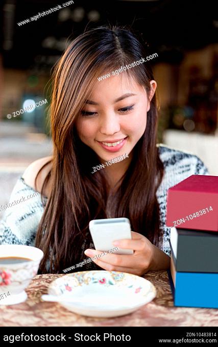 young pretty chinese woman sitting in modern cafe