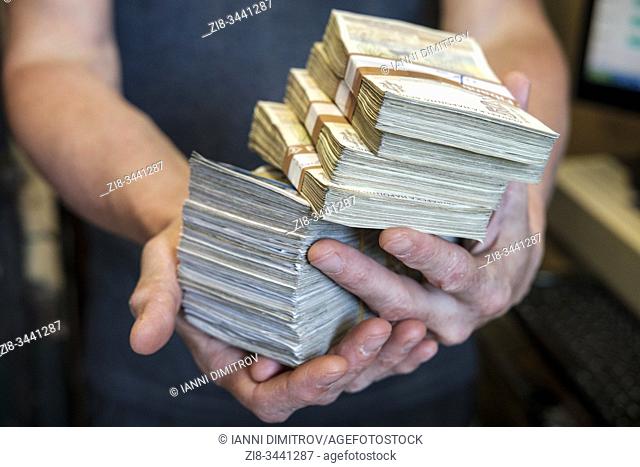 Man holds wads of cash
