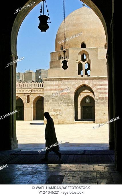Silhouette of Muslim man walking in Mosque of Ahamad ibn Tulun, Cairo. Egypt