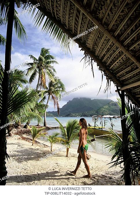 French Polynesia, Bora Bora. Woman walking on beach