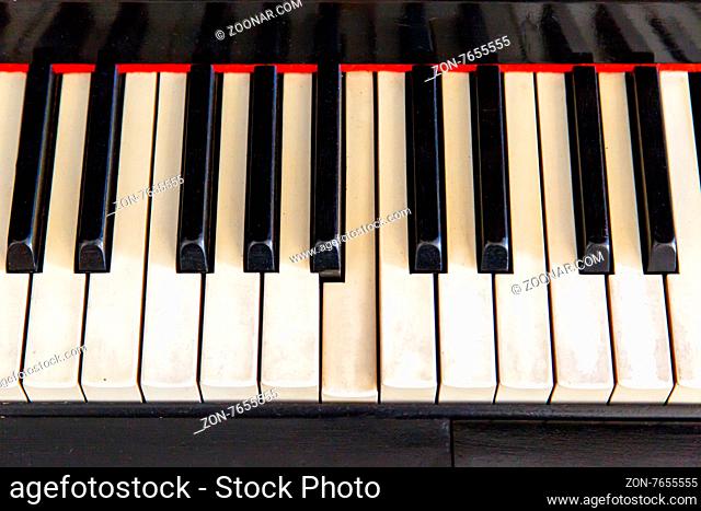 Close up top view of black old piano with white keys on