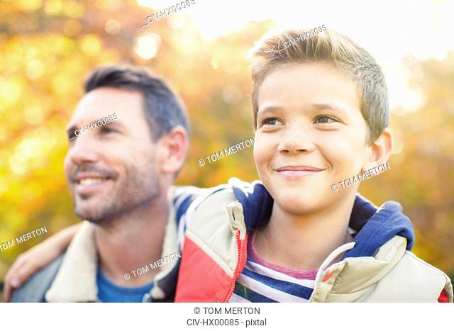Close up smiling father and son hugging outdoors