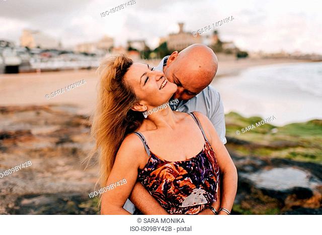 Couple hugging and kissing on beach, Estoril, Lisboa, Portugal