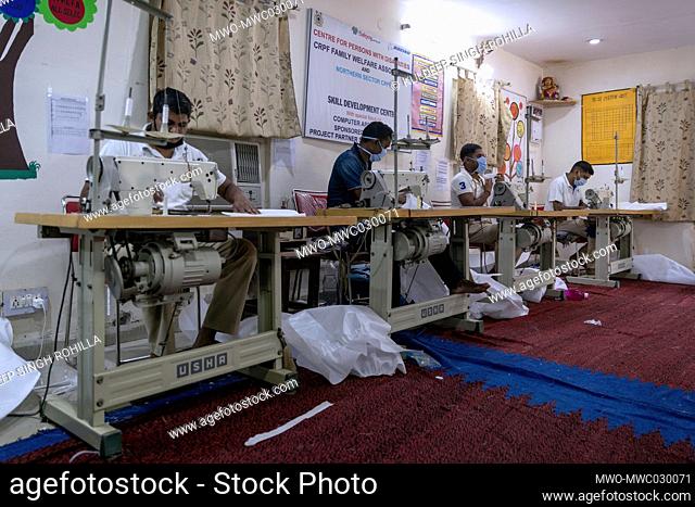 Central Reserve Police Force (CRPF) personnel use sewing machines while manufacturing protective suits at the CRPF Northern Sector staff camp in New Delhi