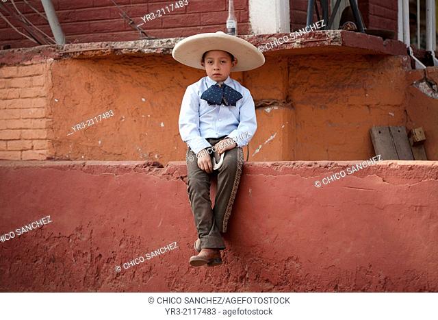 "A boy dressed as a charro carries her horse during an Escaramuza fair in the Lienzo Charros el Penon, Mexico City, Sunday, January 19, 2013