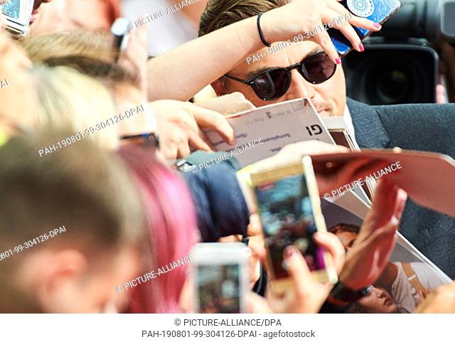01 August 2019, Berlin: Actor Leonardo DiCaprio comes to the premiere of his movie ""Once upon a time...in Hollywood"" and gives autographs to his fans