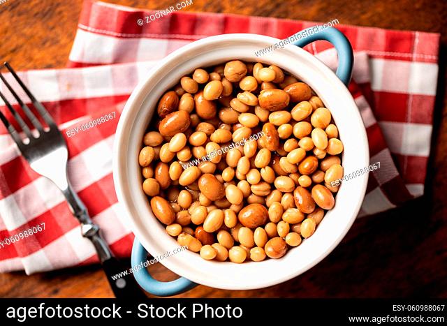 Mix of legume beans and chickpeas with sauce in a pot. Top view
