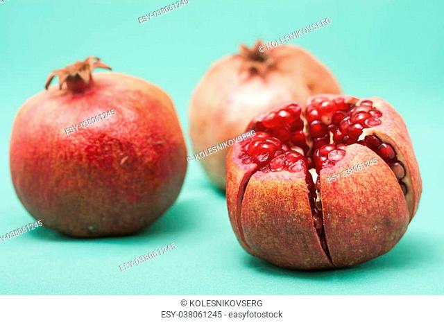 three pomegranate isolated on green background