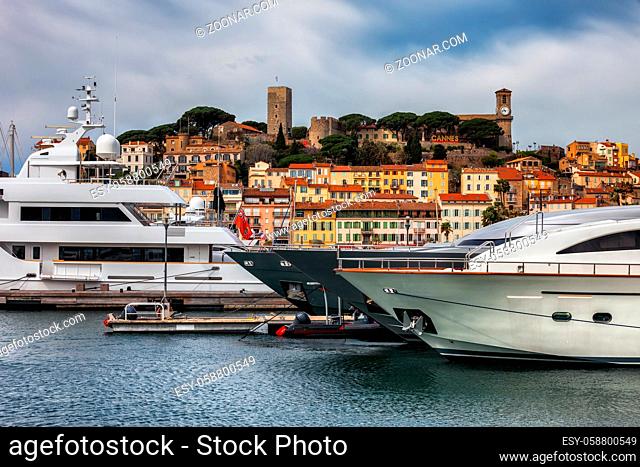 Cannes city in France, luxury yachts at Le Vieux Port on French Riviera, the Old Town - Le Suquet in the background