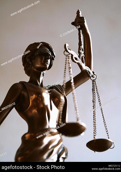 lady justice or justitia - blindfolded figurine holding balance scales - law jurisdiction and impartiality symbol