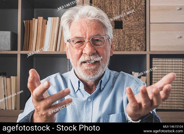 Head shot portrait confident old businessman coach wearing glasses looking at camera and talking, mentor speaker holding online lesson, explaining