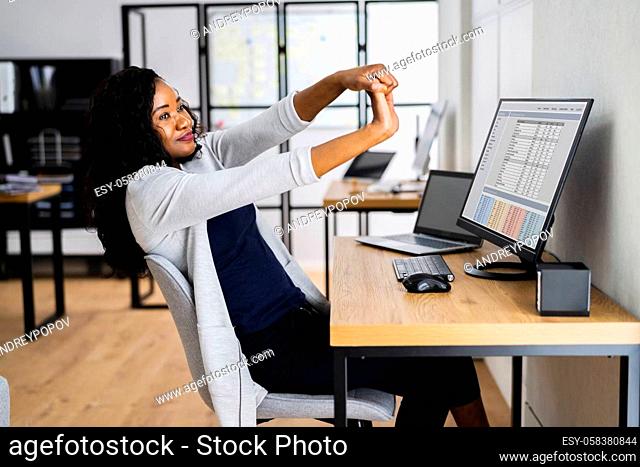 American African Doing Stretch Exercise At Work In Office