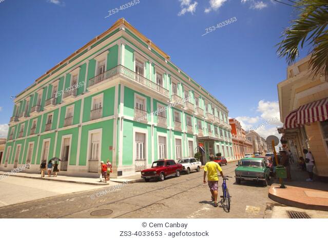 Pedestrian, cyclist and cars in front of the colonial buildings at the historic center, Cienfuegos, Cuba, Central America