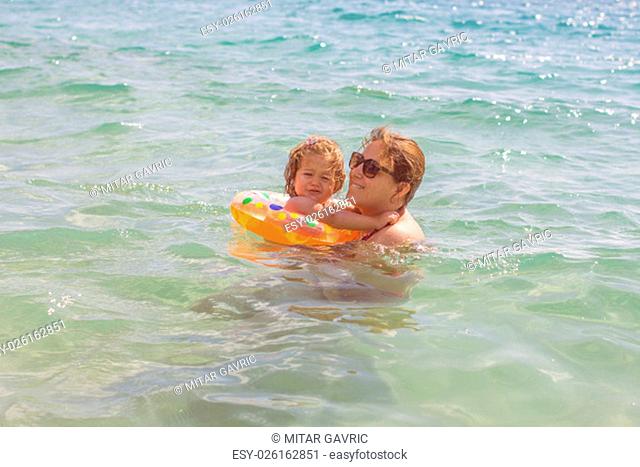 Young Mother and her little girl have fun in the beautiful turquese sea on summer day. Travel Vacation lifestyle
