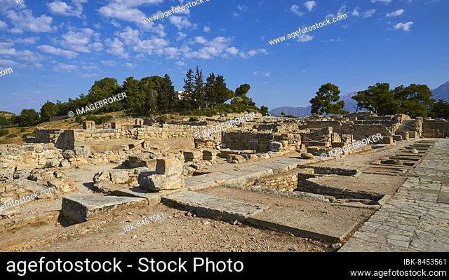 Morning light, blue sky, white clouds, paved roads, ruins of buildings, trees, Minoan Palace of Festos, Messara Plain, Central Crete, Crete Island, Greece