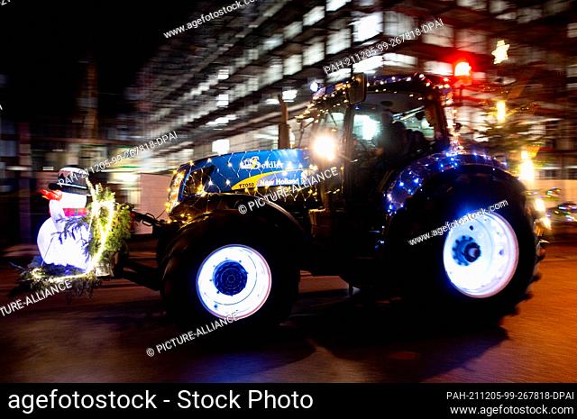 05 December 2021, Bremen: A tractor decorated for Christmas drives through a street in the Horn-Lehe district at the beginning of a drive with lights (camera...