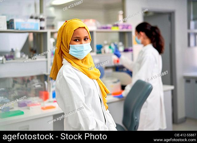 Portrait confident female scientist in hijab and face mask