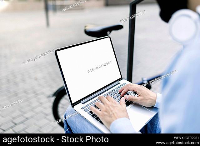Businessman typing on laptop with blank screen