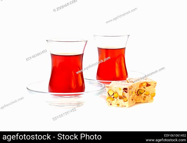 Traditional turkish delight rahat lokum with two glasses of tea on a white background