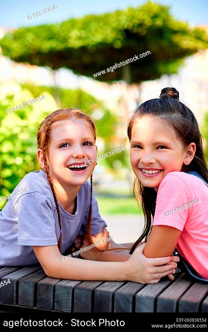 happy cute child girls playing together in the park. friendship and childhood